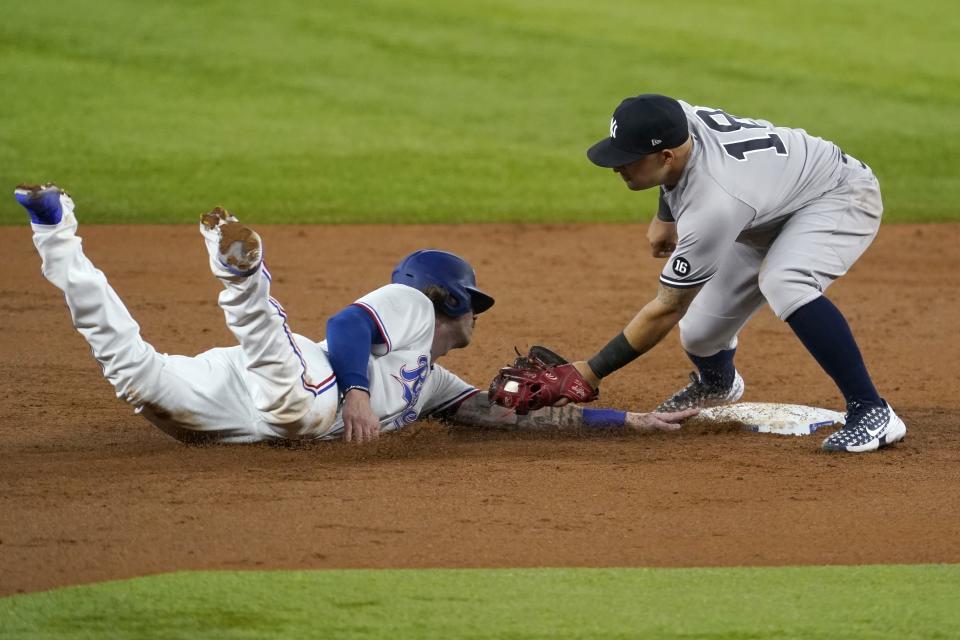 Texas Rangers' Jonah Heim, left, gets back to second safely ahead of the attempted tag by New York Yankees second baseman Rougned Odor, right, in the third inning of a baseball game in Arlington, Texas, Tuesday, May 18, 2021. (AP Photo/Tony Gutierrez)