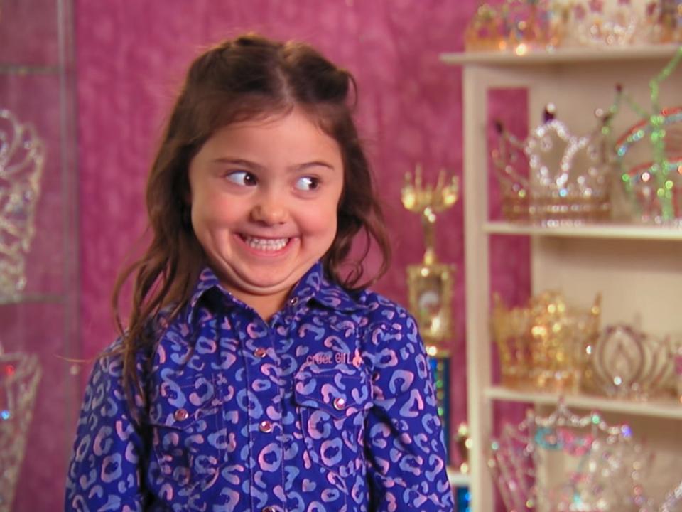 an image of five-year-old kailia posey grinning widely and looking to the side on toddlers and tiaras