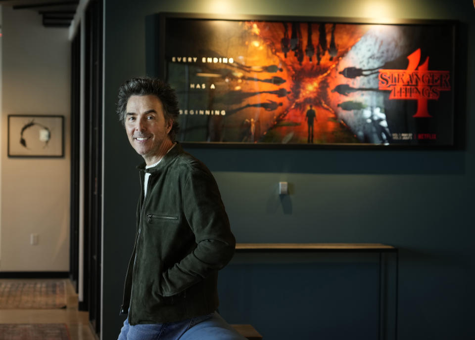 Producer-director Shawn Levy poses for a portrait in his office, Thursday, Oct. 12, 2023, in West Hollywood, Calif., to promote his limited-series "All the Light We Cannot See" based on the best-selling novel. Behind him are artworks for two projects on which he served as a producer, the 2016 film "Arrival," left, and the Netflix series "Stranger Things." (AP Photo/Chris Pizzello)