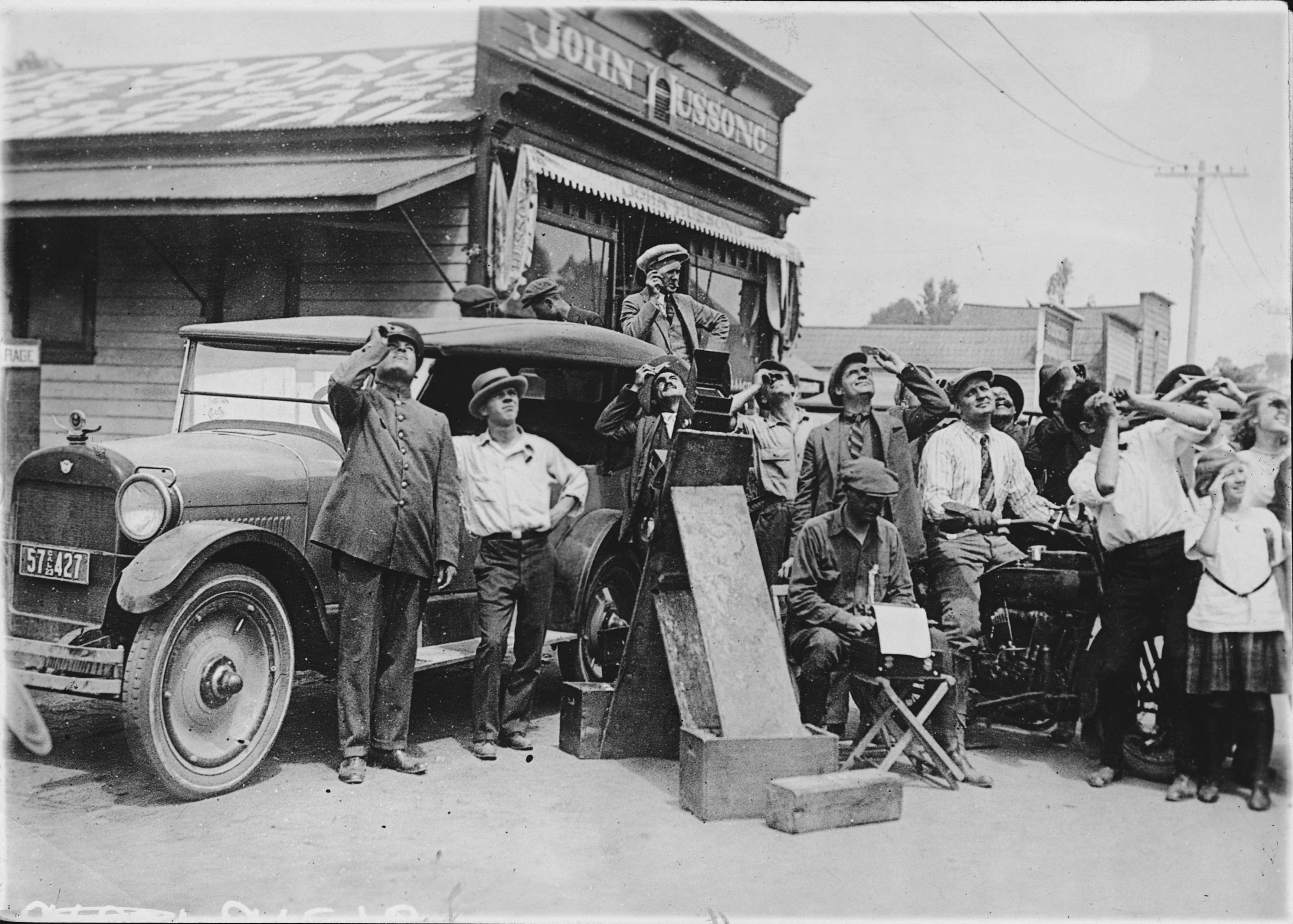 1923: A crowd in a California town observes a total solar eclipse. 