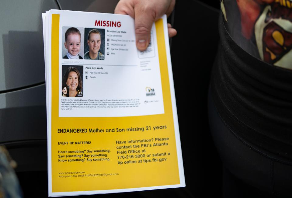 Tara Ramsbottom hands out flyers with  age-progressed images of Paula and Brandon Wade created by the FBI.