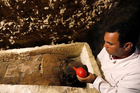 A Egyptian archaeologist is seen next to a coffin inside a tomb during the presentation of a new discovery at Tuna el-Gebel archaeological site in Minya Governorate, Egypt, February 2, 2019. REUTERS/Amr Abdallah Dalsh