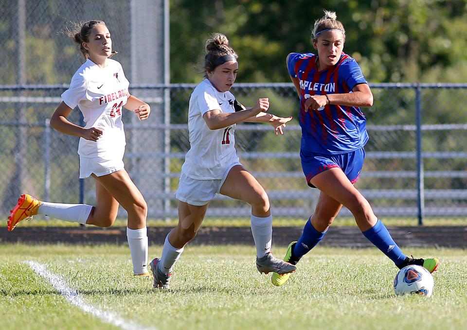 Mapleton High School's Brinlee Youngen (23) works past Firelands High School Cara Mitchell en route to scoring a first half goal during high school girls soccer action Friday, Aug. 12, 2022 at Mapleton High School. TOM E. PUSKAR/ASHLAND TIMES-GAZETTE