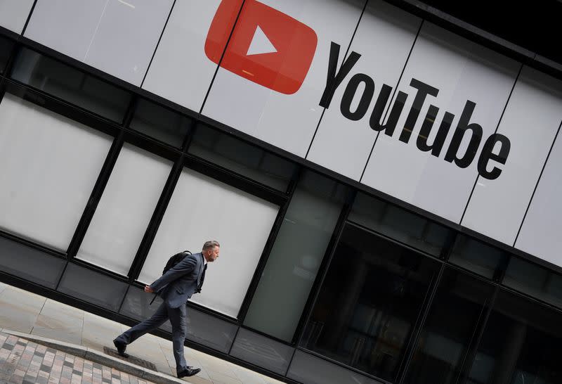 FILE PHOTO: A worker walks past YouTube offices, in King's Cross, London