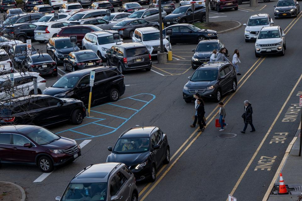 Cars and pedestrians navigate the parking lot on Black Friday at Westfield Garden State Plaza in Paramus, NJ.