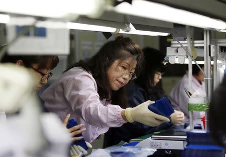 Kim Yeon-soon, 55, who is an elderly worker at the quality control team and leading a dozen of workers, checks the final products at a factory in Ansan March 2, 2015. REUTERS/Kim Hong-Ji