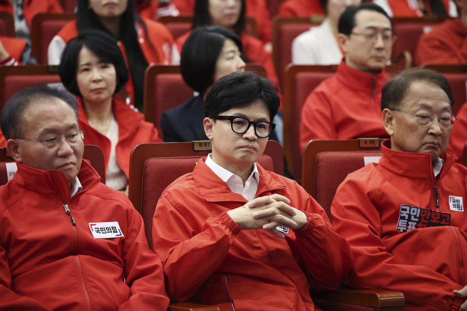 The ruling People Power Party's leader Han Dong-hoon, center, and party members watch TV broadcasting results of exit polls for the parliamentary election at the National Assembly on Wednesday, April 10, 2024 in Seoul, South Korea. (Kim Hong-Ji/Pool Photo via AP)