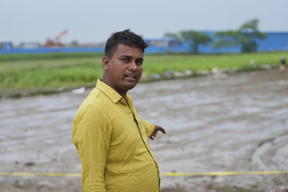 Sonu Kumar points towards the scene of a stampede while speaking with the Associated Press at Hathras district, Uttar Pradesh, India, Wednesday, July 3, 2024. Kumar was one of many local residents who helped lift and move dead bodies after the accident. "The screams were so heart-wrenching. We have never seen anything like this before in our village," Kumar said. (AP Photo/Rajesh Kumar Singh)