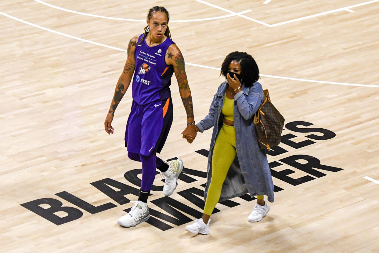 Brittney Griner holds her wife Cherelle Watson's hand after defeating the Dallas Wings on August 10, 2020 in Palmetto, Fla. (Douglas P. DeFelice / Getty Images)