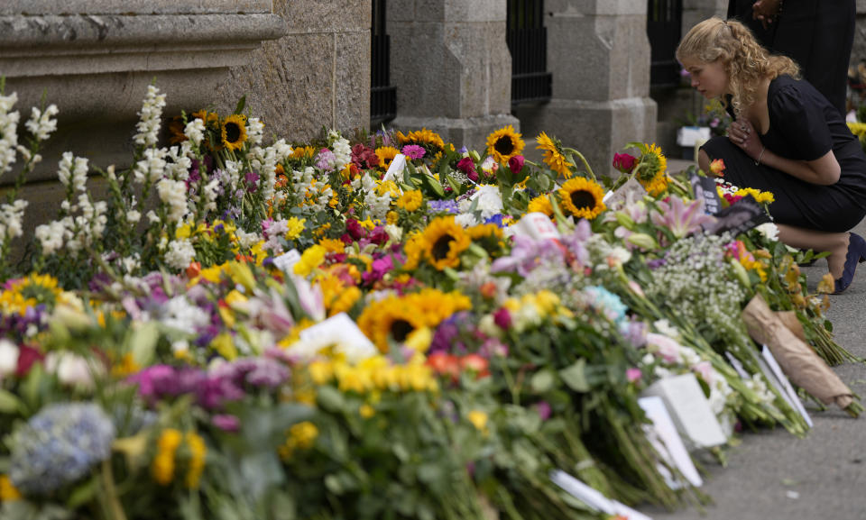 Lady Louise Windsor looks at floral tributes to her grandmother Queen Elizabeth II outside the gates of Balmoral Castle in Aberdeenshire, Scotland Saturday, Sept. 10, 2022. Queen Elizabeth II, Britain's longest-reigning monarch and a rock of stability across much of a turbulent century, died Thursday after 70 years on the throne. She was 96. (AP Photo/Alastair Grant)