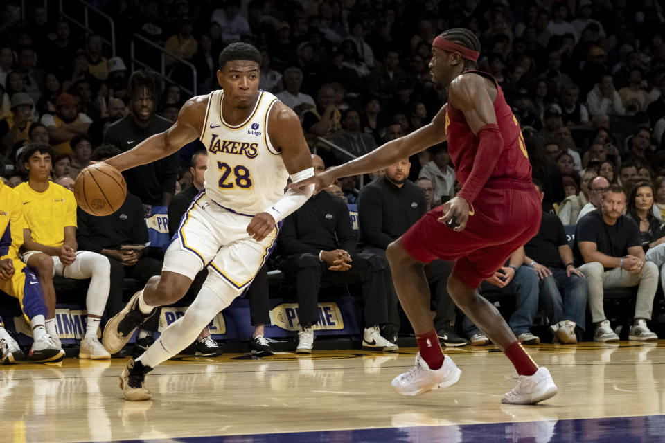 Los Angeles Lakers forward Rui Hachimura (28) drives past Cleveland Cavaliers guard Caris LeVert (3) during the first half of an NBA basketball game Saturday, April 6, 2024, in Los Angeles. (AP Photo/William Liang)