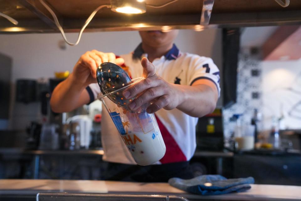 Alvin Nguyen, owner, makes a milk tea drink at Aloha Tea & Coffee on Thursday, March 10, 2022, in Glendale.