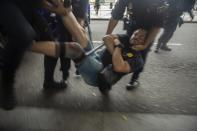 In this Monday, Oct. 14, 2019 photo, Spanish police carry a pro-independence protesters during a demonstration at El Prat airport, outskirts of Barcelona, Spain. Riot police engaged in a running battle with angry protesters outside Barcelona's airport Monday after Spain's Supreme Court convicted 12 separatist leaders of illegally promoting the wealthy Catalonia region's independence and sentenced nine of them to prison. (AP Photo/Joan Mateu)