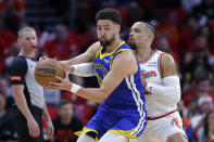 Houston Rockets forward Dillon Brooks, right, reaches in as Golden State Warriors guard Klay Thompson, left, spins on a drive to the basket during the first half of an NBA basketball game Thursday, April 4, 2024, in Houston. (AP Photo/Michael Wyke)