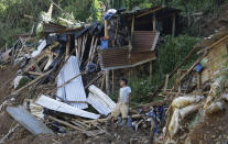 <p>In this Monday, Sept. 17, 2018, file photo, a resident stands beside toppled houses at the site where victims are believed to have been buried by a landslide after Typhoon Mangkhut lashed Itogon, Benguet province, northern Philippines. Itogon Mayor Victorio Palangdan said that at the height of the typhoon’s onslaught Saturday afternoon, dozens of people, mostly miners and their families, rushed into an old three-story building in the village of Ucab. The building, a former mining bunkhouse that had been transformed into a chapel, was obliterated when part of a mountain slope collapsed. (AP Photo/Aaron Favila, File) </p>