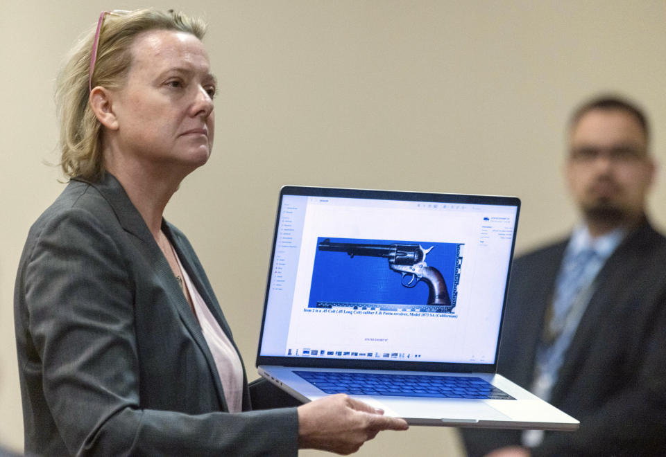 CORRECTION: REMOVES REFERENCE ABOUT OWNERSHIP OF GUN - Special prosecutor Kari Morrissey shows defense attorney Jason Bowles a picture of a firearmReed during Hannah Gutierrez-Reed trial at District Court, Monday, Feb. 26, 2024, in Santa Fe, N.M. Gutierrez-Reed is charged with involuntary manslaughter and tampering with evidence in the October 2021 death of cinematographer Halyna Hutchins during the filming of the Western “Rust”. (Luis Sánchez Saturno/Santa Fe New Mexican via AP, Pool)