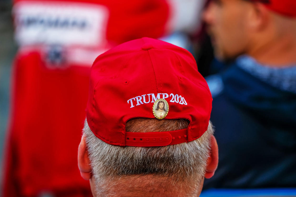 A man has a Jesus Christ pin affixed to a Trump 2020 hat during a Make American Great Again rally. Preston Ehrler/SOPA Images/LightRocket via Getty Images