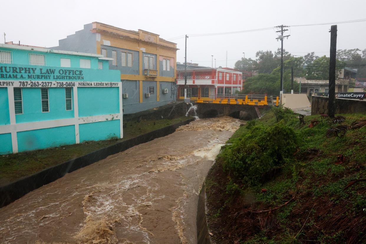 A river swollen with rain caused by Hurricane Fiona speeds through Cayey, Puerto Rico, Sunday, Sept. 18, 2022.