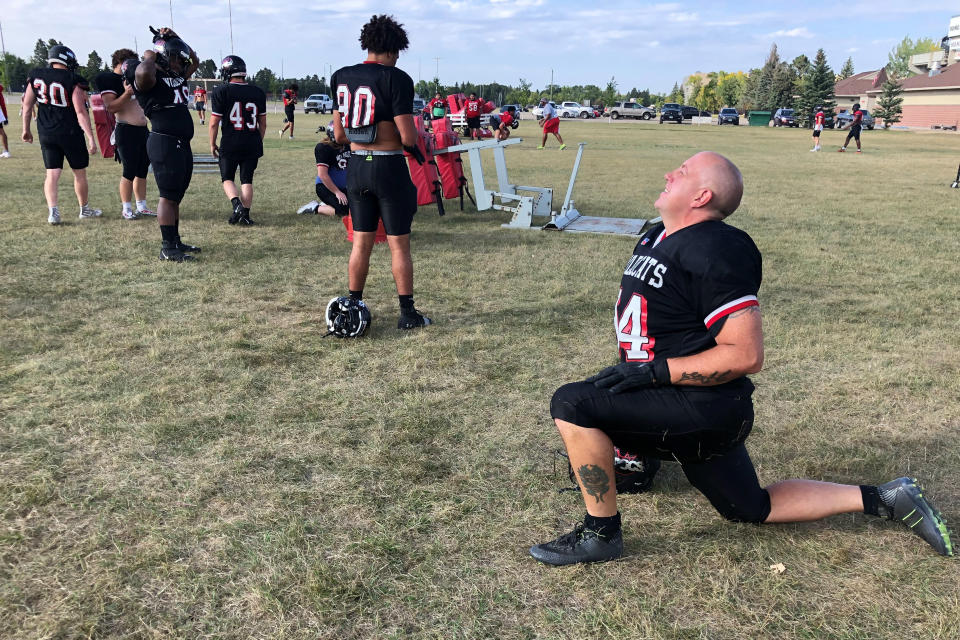 Ray Ruschel, a 49-year-old freshman football player for the North Dakota State College of Science, takes his turn on the blocking sled on Tuesday, Sept. 20, 2022, in Wahpeton, N.D. Ruschel had not played football since he was in high school in Pennsylvania. The Army veteran is a night-shift mechanic at a local sugar beet factory. He is seeking a degree in business management after his most recent deployment with the National Guard. He hopes to become a supervisor at work. For now, he is holding his own with 19- and 20-year-old football players on a team with national title hopes.. (AP photo/Dave Kolpack)