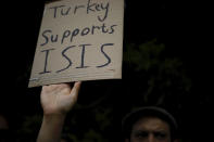 An Israeli protester holds a sign and shouts slogans during a demonstration against Turkey's military action in Syria, outside the Turkish embassy in Tel Aviv, Israel, Tuesday, Oct. 15, 2019. (AP Photo/Ariel Schalit)