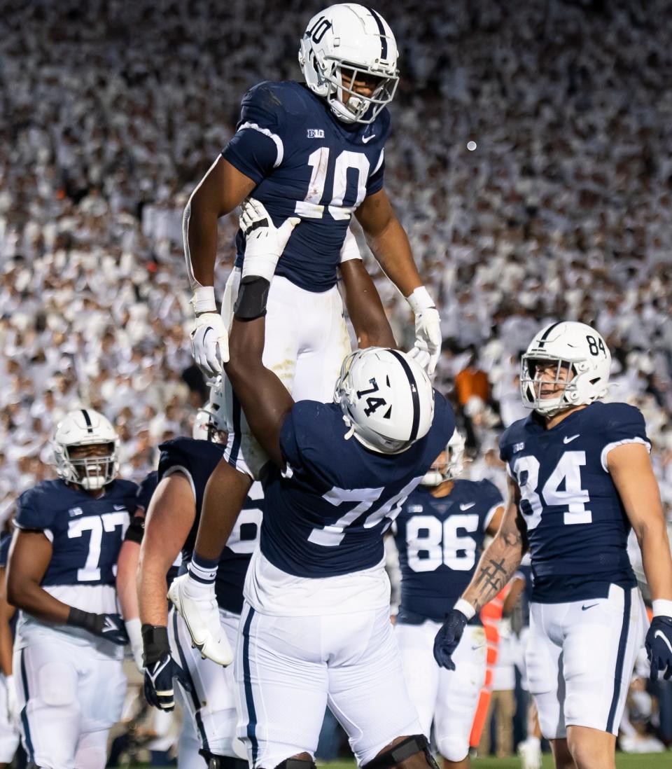 Penn State offensive lineman Olumuyiwa Fashanu (74) lifts up running back Nick Singleton (10) after the freshman running back scored his first of two touchdown against Minnesota at Beaver Stadium on Saturday, Oct. 22, 2022, in State College.