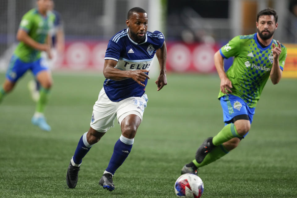 Vancouver Whitecaps midfielder Junior Hoilett, left, moves the ball against Seattle Sounders midfielder João Paulo, right, during the first half of an MLS soccer match Saturday, Oct. 7, 2023, in Seattle. (AP Photo/Lindsey Wasson)