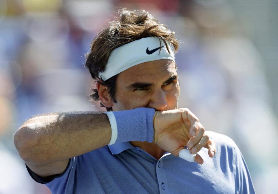 FILE - In this March 16, 2014 file photo, Roger Federer of Switzerland wipes his face during the BNP Paribas Open tennis tournament in Indian Wells, Calif. Federer announced on Tuesday May 6, 2014 that has withdrawn from the Madrid Open to spend more time with his family ahead of the birth of his third child. Federer's announcement means he will likely miss the Rome Masters next week. (AP Photo/Mark J. Terrill, File)