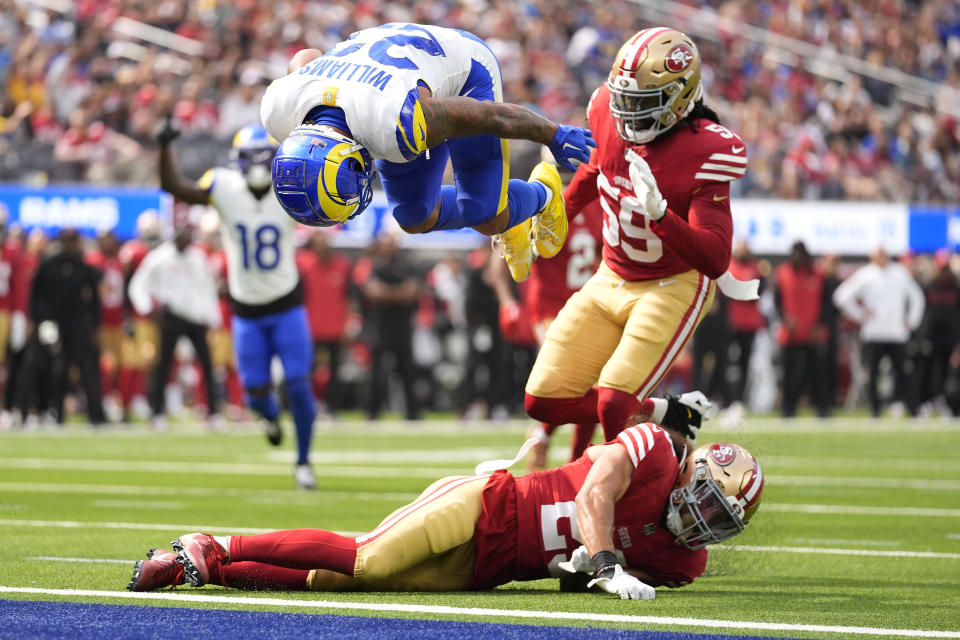 Los Angeles Rams running back Kyren Williams, top, flips into the end zone to score against San Francisco 49ers safety Talanoa Hufanga, bottom, and linebacker De'Vondre Campbell during the first half of an NFL football game, Sunday, Sept. 22, 2024, in Inglewood, Calif. (AP Photo/Ashley Landis)