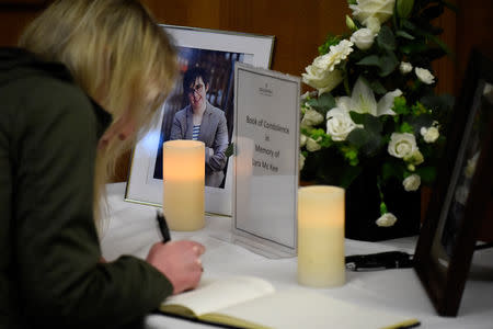 FILE PHOTO: A woman signs a book of condolences in the Guildhall for the 29-year-old journalist Lyra McKee who was shot dead in Londonderry, Northern Ireland April 20, 2019. REUTERS/Clodagh Kilcoyne/File Photo