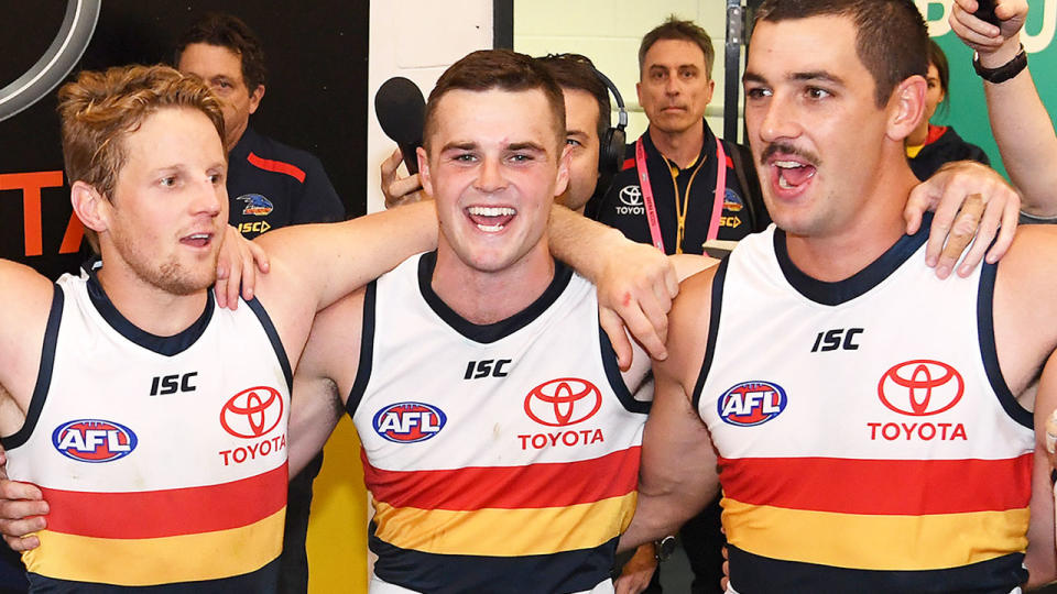 Pictured in the centre, Brad Crouch celebrates after a game with Adelaide Crows teammates.