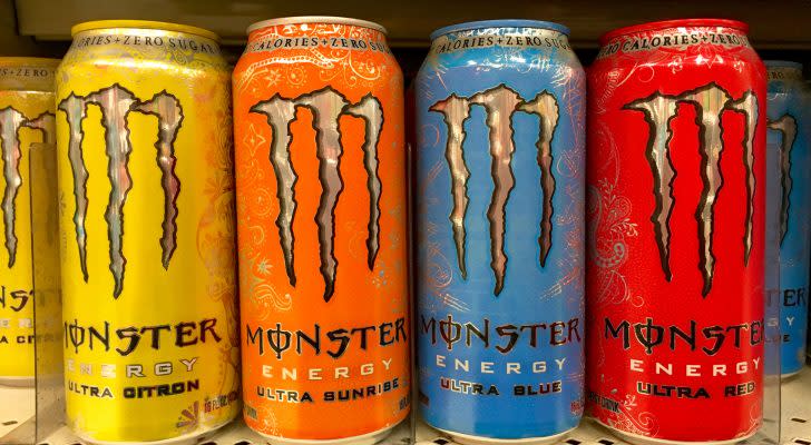 Grocery store shelf with 16 ounce cans of Monster brand energy drinks.