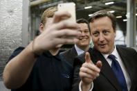 Britain's Prime Minister David Cameron (R) poses for a selfie with an apprentice during a visit to the Spooner engineering works in Ilkley, northern England in this February 5, 2015 file photo. REUTERS/Phil Noble/Files FROM THE FILES PACKAGE 'POLITICIAN SELFIES' SEARCH 'POLITICIAN SELFIES' FOR ALL 13 IMAGES