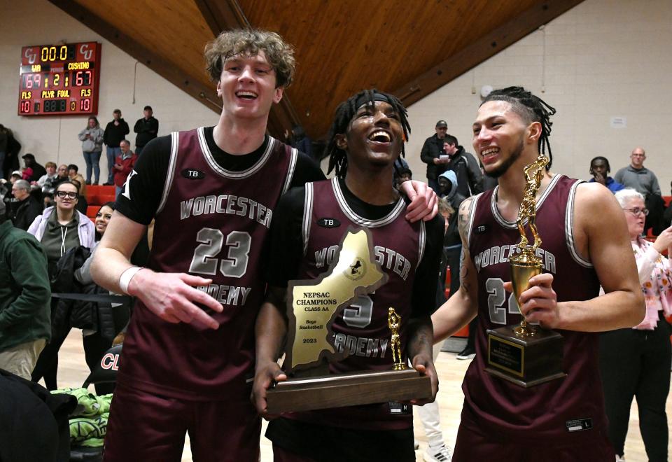 Kayvaun Mulready, right, holds his MVP trophy while celebrating with teammate T.J. Power and Tre Norman after Worcester Academy captured the NEPSAC Class AA title on March 6.