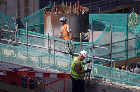 FILE PHOTO: Builders work on a construction site in London, Britain August 17, 2016. REUTERS/Neil Hall