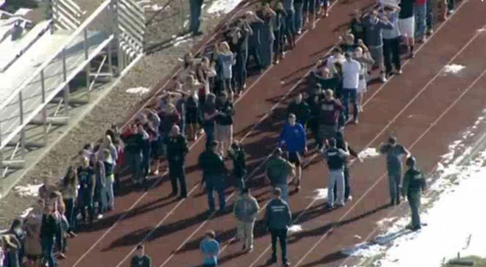 Students from Arapahoe High School evacuate their building in Centennial, Colorado December 13, 2013 in this still image from video Courtesy KUSA, Channel 9 during a shooting incident in which at least two students were injured. Police reported the gunman took his own life. REUTERS/Courtesy KUSA, Channel 9 (UNITED STATES - Tags: CRIME LAW) NO SALES. NO ARCHIVES. FOR EDITORIAL USE ONLY. NOT FOR SALE FOR MARKETING OR ADVERTISING CAMPAIGNS. THIS IMAGE HAS BEEN SUPPLIED BY A THIRD PARTY. IT IS DISTRIBUTED, EXACTLY AS RECEIVED BY REUTERS, AS A SERVICE TO CLIENTS