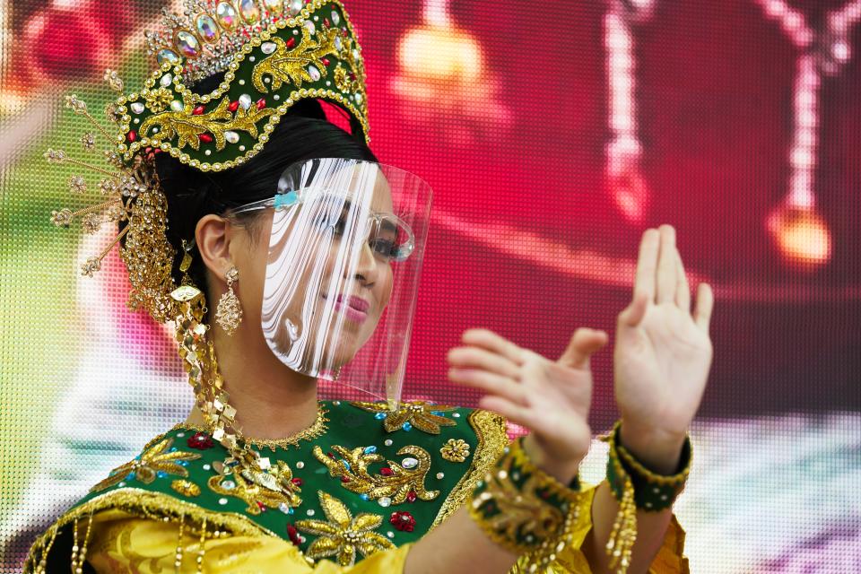 A dancer from Malaysia's pavilion performs wearing a face shield due to the coronavirus at Expo 2020, in Dubai, United Arab Emirates, Sunday, Oct. 3, 2021. (AP Photo/Jon Gambrell)