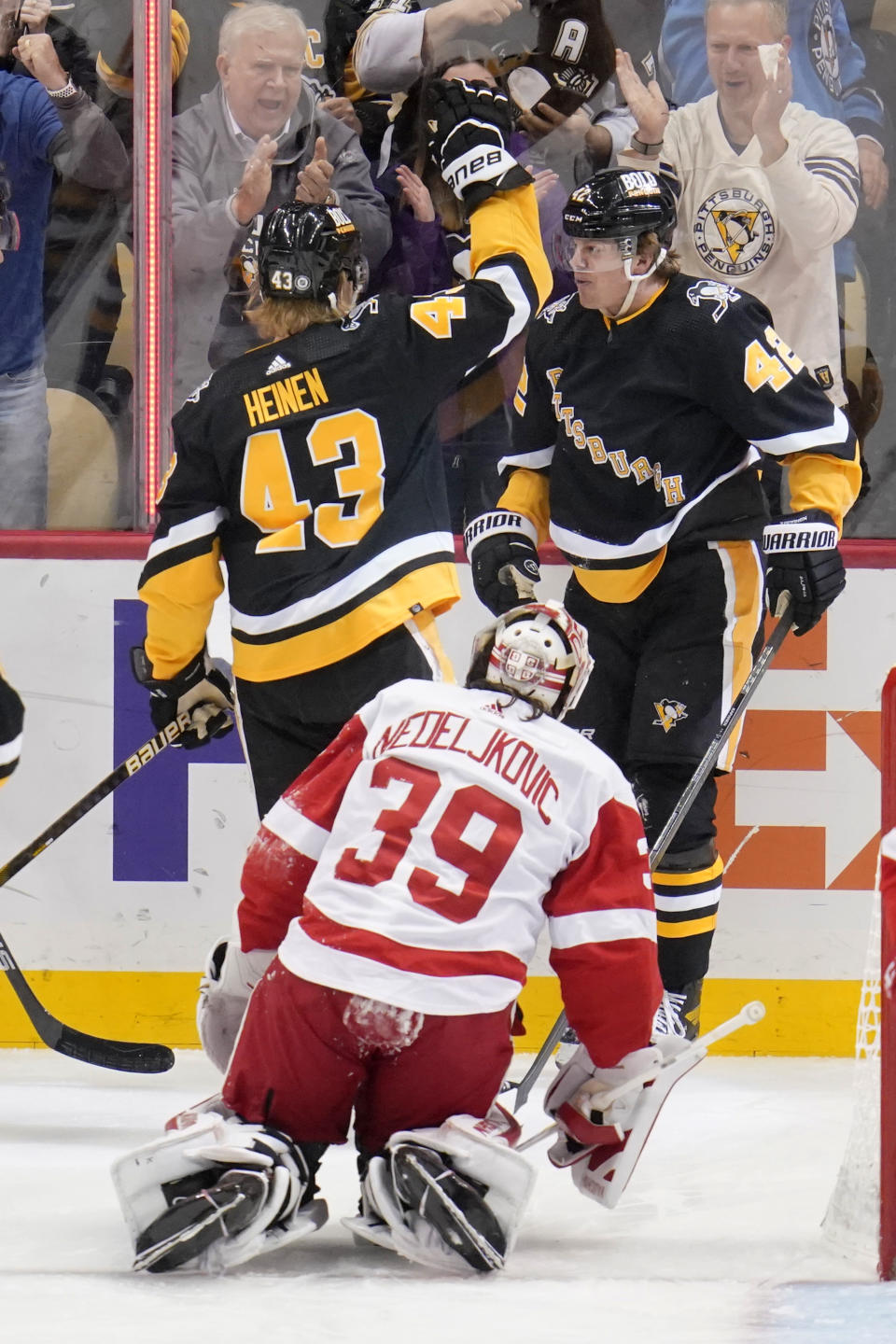 Pittsburgh Penguins' Kasperi Kapanen (42) celebrates with teammate Danton Heinen (43) after scoring as Detroit Red Wings goaltender Alex Nedeljkovic (39) looks on during the first period of an NHL hockey game in Pittsburgh, Sunday, March 27, 2022. (AP Photo/Gene J. Puskar)