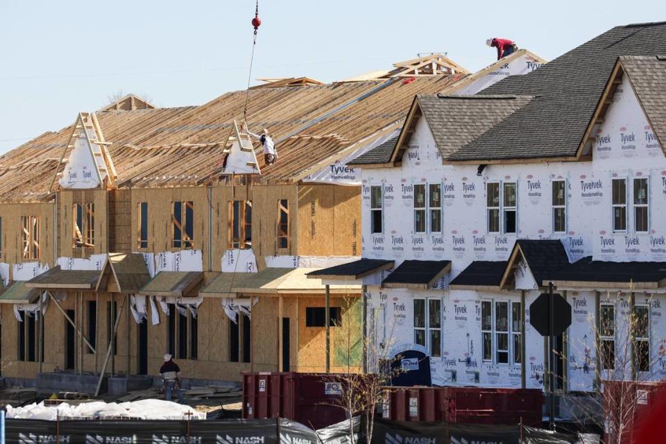 At townhouses under construction near Charlotte’s University City neighborhood, workers tackle what can be a dangerous job — building the roof. Neither of the workers on the roof is wearing a safety harness.