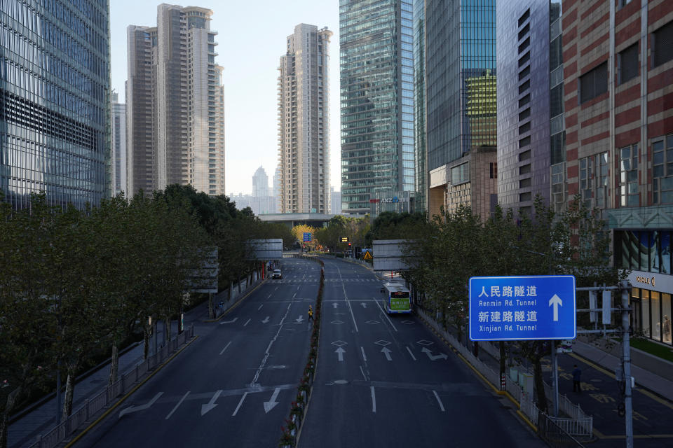 Un repartidor cruza una carretera vacía en el distrito financiero de Lujiazui, mientras continúan los brotes de la enfermedad por coronavirus (COVID-19) en Shanghái, China, el 19 de diciembre de 2022. REUTERS/Aly Song