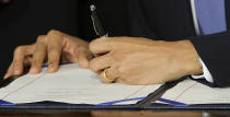 FILE - In this March 23, 2010, file photo, President Barack Obama signs the health care bill in the East Room of the White House in Washington. On Friday, Oct. 23, 2020, The Associated Press reported on stories circulating online incorrectly asserting Democrats voted to fine American citizens for not buying health insurance and conspired to give it to “illegal aliens” for free. The Affordable Care Act, which originally included fines for not buying health insurance, excludes immigrants living in the country without legal permission from receiving tax credits or purchasing insurance on the ACA marketplace. (AP Photo/J. Scott Applewhite, File)