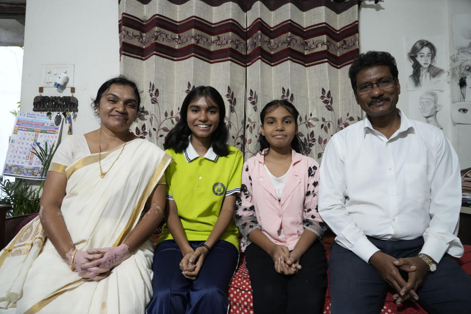 Gautam Dongre, of the National Alliance of Sickle Cell Organizations, sits with his daughters, Sumedha, 13, second right, a patient of sickle cell disease, and Rushali, 15, and his wife, Padmashri, at their residence in Nagpur, India, Wednesday, Dec. 6, 2023. (AP Photo/Ajit Solanki)