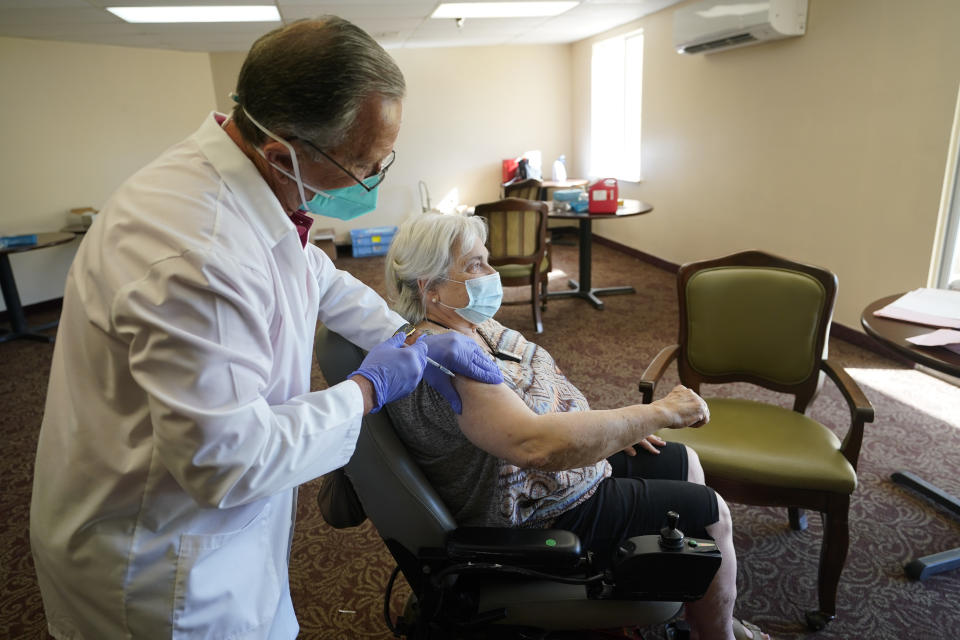 Registered Pharmacist Ken Ramey, left, prepares to inoculate Deanna Sutton, 83, with the COVID-19 vaccine, Thursday, Jan. 21, 2021, at the Isles of Vero Beach assisted and independent senior living community in Vero Beach, Fla. (AP Photo/Wilfredo Lee)