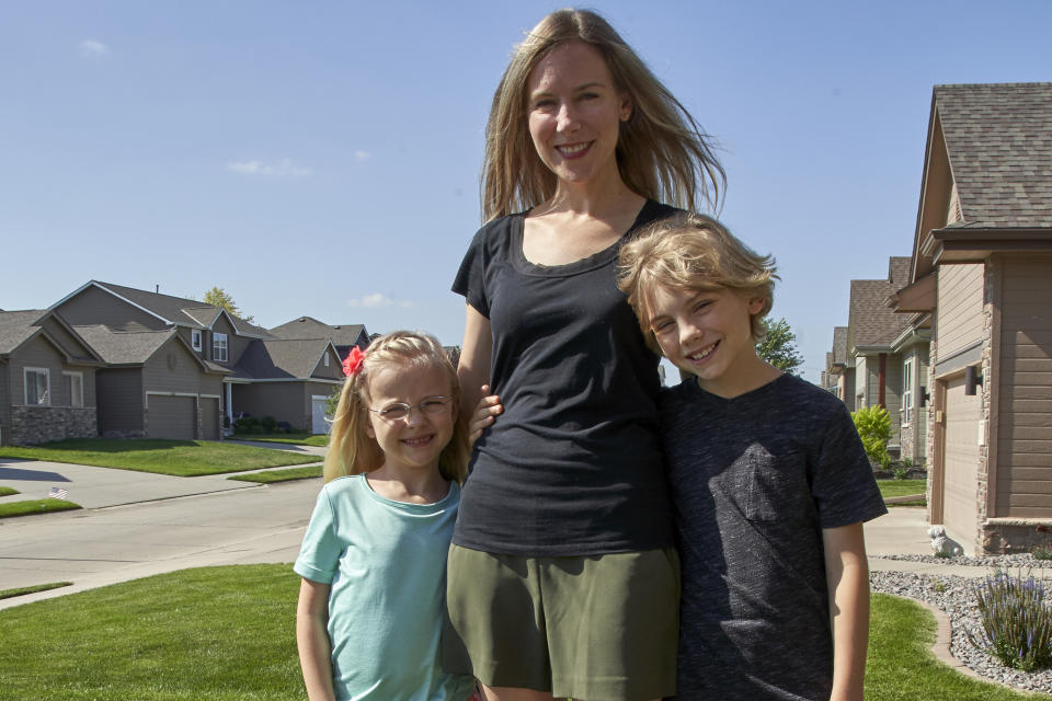 Tara Carlson poses for a photo with her children Kyler, 9, and Alayna, 6, outside their home in Omaha, Neb., Tuesday, July 7, 2020. Carlson pulled her kids out of summer camp at the last minute, losing $300 in deposits. (AP Photo/Nati Harnik)