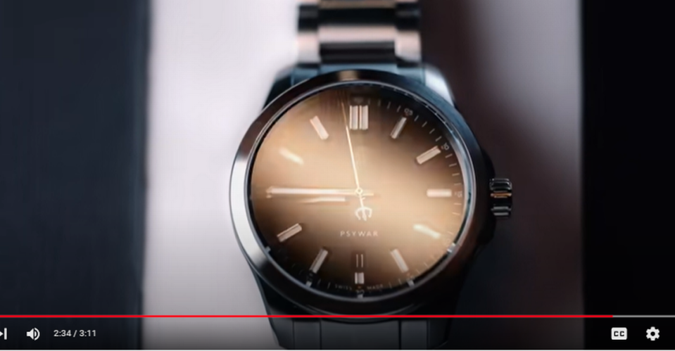 This ticking watch has a pitchfork as its seconds hand in the video and the word “PSYWAR” on the clock face. YouTube video screengrab
