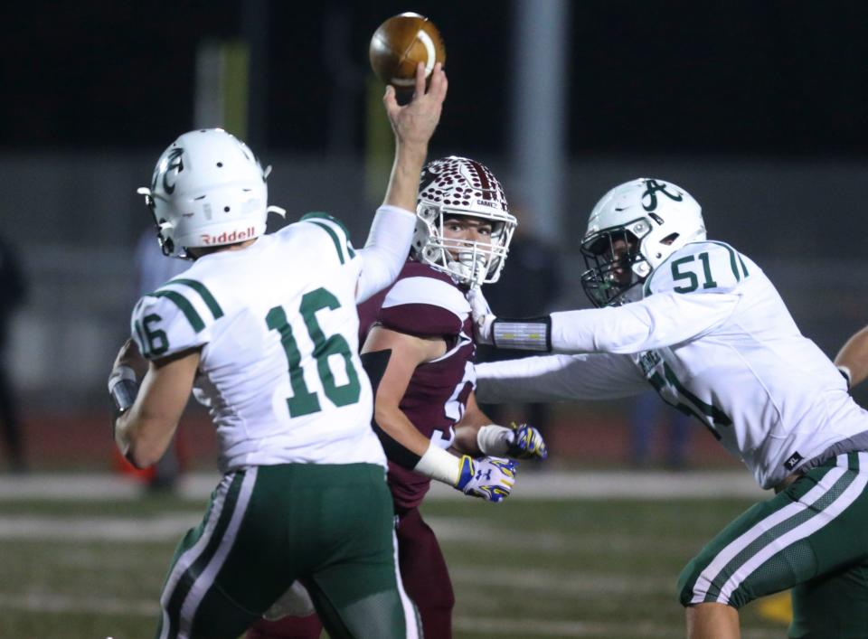Caravel's Owen Robinson (center) works against Archmere's John Dellose in Caravel's 30-6 win in the semifinals of the DIAA Class 2A state tournament Friday, Dec. 2, 2022 at Bob Peoples Stadium, 