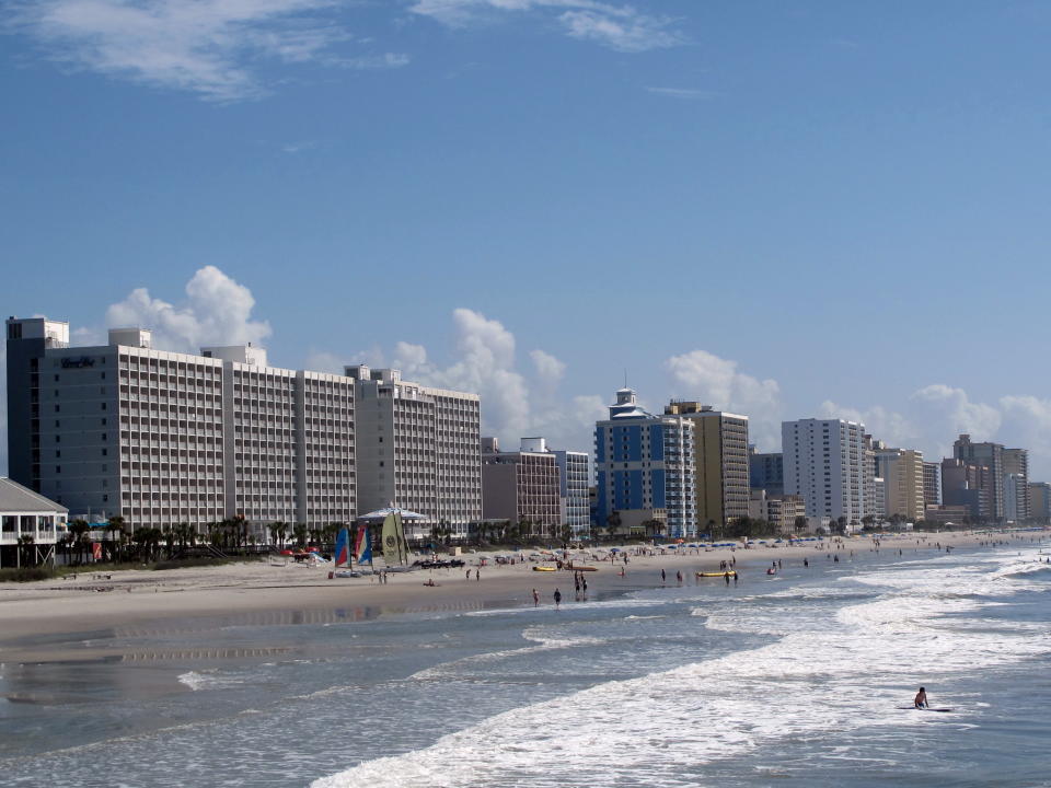 This May 22, 2013 photo shows vacationers on the beach in Myrtle Beach, S.C. Each year about 14 million visitors are drawn by the 60 miles of beaches along the northeast coast of South Carolina. The beaches are public and there are frequent beach access points along the coast. (AP Photo/Bruce Smith)