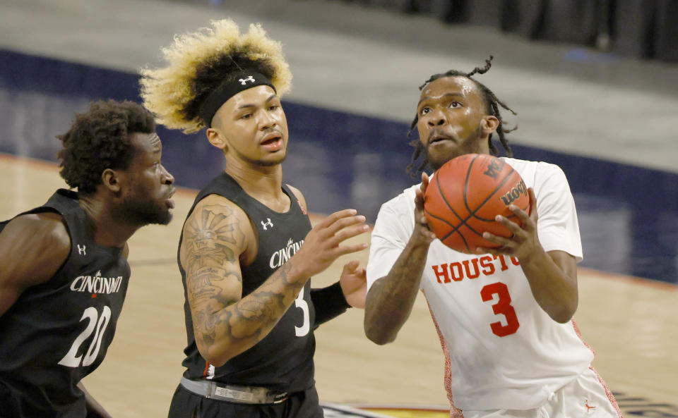 Houston guard DeJon Jarreau, right, drives inside as Cincinnati forward Mamoudou Diarra (20) and Cincinnati guard Mike Saunders, center, defend during the first half of an NCAA college basketball game in the final round of the American Athletic Conference men's tournament Sunday, March 14, 2021, in Fort Worth, Texas. (AP Photo/Ron Jenkins)