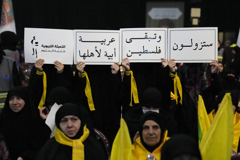 Hezbollah women supporters holds Arabic placards that read:"You will gone and Palestine will remain Arab and proud of its people," during a rally to mark Jerusalem day, in a southern suburb of Beirut, Lebanon, Friday, April 14, 2023. Since Iran's Islamic Revolution in 1979, the rallies marking what is also known as al-Quds Day have typically been held on the last Friday of the Muslim holy month of Ramadan. (AP Photo/Hussein Malla)