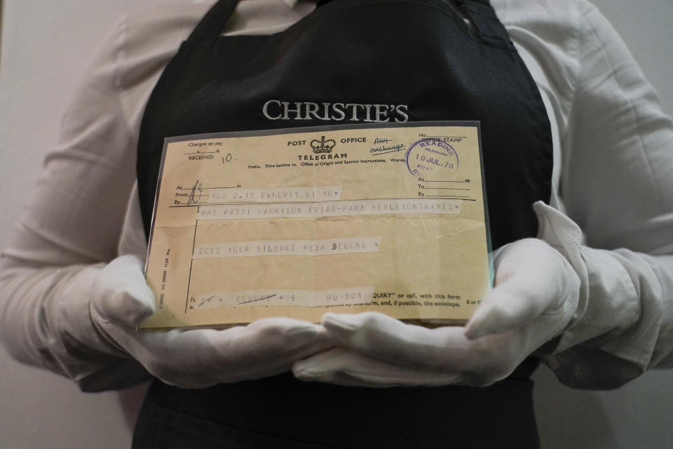A member of staff holds a telegram sent by Eric Clapton in 1970, as part of The Pattie Boyd Collection at Christie's, in London, Thursday, March 14, 2024. The telegram is estimated to sell £1,000-1,500. (AP Photo/Alberto Pezzali)