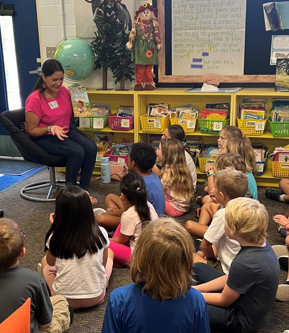 Volunteer Carolina Franco of CreArte Latino Cultural Center leads a Bucket Fillers reading session with second-grade students at Palma Sola Elementary in Bradenton.